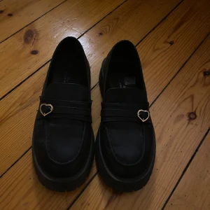 Loafers - Svarta loafers, gullig modell med hjärta spänne
