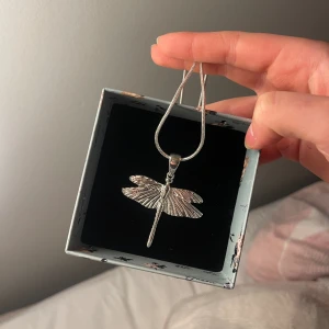 ioaku single chain mini dragonfly halsband - Säljer mitt ioaku halsband i silver då den inte kommer till andvänding. Köpte den precis innan julen och bara använt på julafton, jag har även lådan kvar.❤️