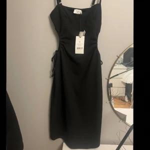 Klänning - En helt oanvänd klänning ifrån NA-KD med öppet på sidorna. Säljer då den är lite stor på mig som i vanliga fall brukar ha S. Skriv för fler bilder💕