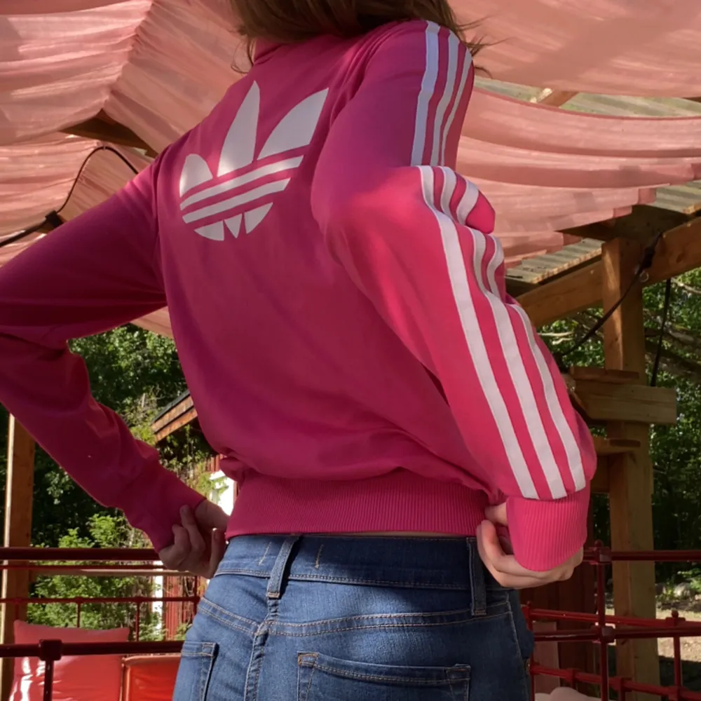 Rosa adidas hoodie skick 8/10 då den har två fläckar se på bild 5 en grå vid armvecket och en vid arm mudden men dem är nästan omärkbara storlek M/L men passar mig som vanligt vis har S. Hupparit & Collegepaidat.