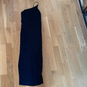 Sommar klänning  - En medellång klänning med one shoulder och slits bak 