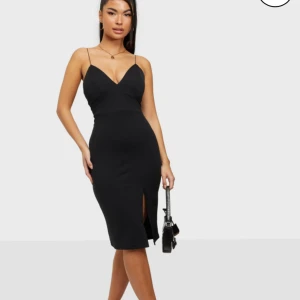 Klänning - Svart klänning med slits. Fint skick. Storlek M.