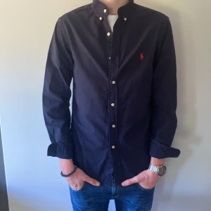 Marinblåskjorta  - Säljer nu denna riktigt snygga skjorta ifrån Ralph lauren. Modellen är 183. Inga defekter eller liknande. Bara att skriva vid frågor eller funderingar.