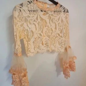 Spets topp trumpetärmar med volanger - Såå otroligt vacker spetsblus/topp med galet vackra trumpetärmar med volanger. Toppen är i jätte fint skick. Unik! 💕💕