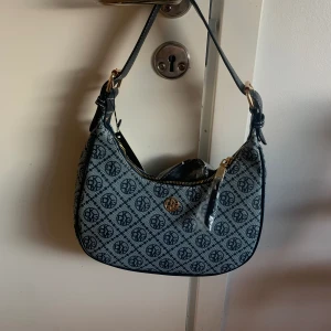 Axelväska - Väskan är helt ny med prislapp! Jag köpte den för 200kr+ men jag ska sälja den för 100kr, dock kan pris diskuteras! Produktmåtten: längd: 26cm, bredd: 6,5cm, höjd: 14,5cm