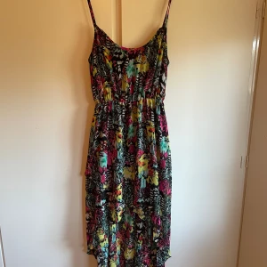 Klänning med korsade band i rygg  - Kortare i fram, längre i bak. Korsade band på ryggen.  Fint skick