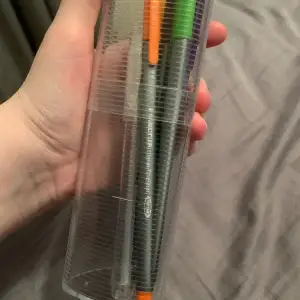 Några pennor.   Det är:  1 mörk grön  1 ljus grön  1 brun  1 gul  1 orange  1 lila  1 röd  och 1 silver 