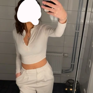 Vit tröja med dragkedja - En vit tröja med dragkedja. Den ser ganska genomskinlig ut pågrund av att jag hade på mig svart bh men har man vit eller beige bh under så syns det inte lika mycket.