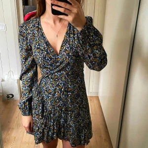 Långärmad klänning - Jag säljer min blommiga långärmade klänning från Bikbok då den aldrig kommer till användning. Har ett knyte i midjan så passar även mindre storlekar. Jag är 172 cm lång. Nypris 399kr. 🩵