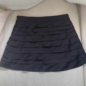 Svart kjol - Säljer denna kjol med volanger eftersom att den inte kommer till användning. Kjolen är felfri och har en dragkedja på sidan. Köpte den i Spanien så vet inte nypriset.