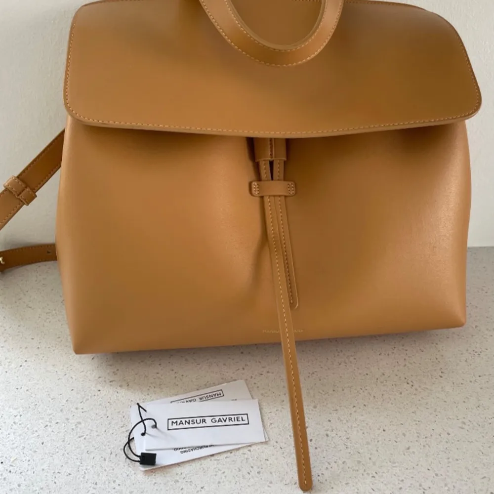 Hej,   Säljer en helt ny väska ifrån Mansur gavriel, självklart äkta.  Brun/beige skinn med rosa insida.   Nypris 8900 kr.  . Väskor.