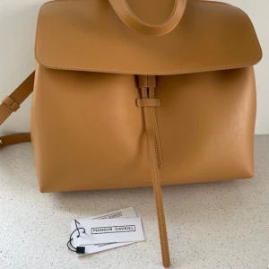 Brun skinnväska  - Hej,   Säljer en helt ny väska ifrån Mansur gavriel, självklart äkta.  Brun/beige skinn med rosa insida.   Nypris 8900 kr.  