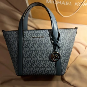 Michael Kors Pratt väska till salu 👛💘 - 18X18X10cm väska från märket Michael Kors💞 Fått denna vackra väskan till present och har dessvärre inte använt den, och kom fram till att sälja den då jag ej har ytterligare plats för ännu en väska☺️  Originalkasse & tagg medföljer🛍️❤️ Nypris: 3900kr🫶🏻