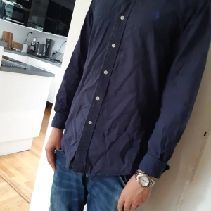 Ralph Lauren skjorta - Tja! Säljer denna super snygga Polo Skjortan. Den är i jättebra skick och i en snygg marinblå färg. Skrov om du har någon fråga!