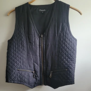 Väst - Kortare väst i nylon/polyester. Fint skick. Liten M