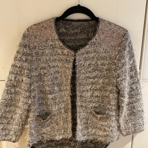 Trekvartsärmad kofta  - Så fin trekvartsärmad kofta med guldiga paljettdetaljer samt fickor. Knappt använd. Stl M