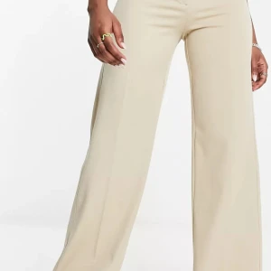 Beigea kostymbyxor  - Snygga kostymbyxor med vida ben. Tighta vid rumpan. Använda 1 gång.