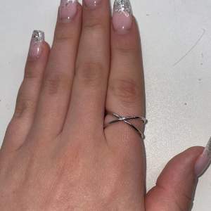 En silver ring som är format som ett kryss
