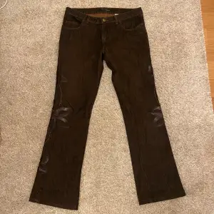 Bruna lågmidjade jeans med detaljer på sidan. Storlek 30 (s/m). Bra skick.