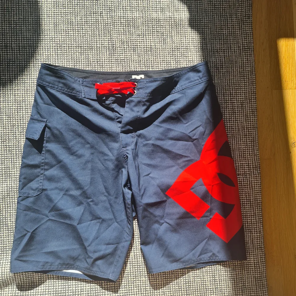 Mörkblå badshorts/boardshorts från DC Shoes Lanai 22 Strl 14 (S)  Oanvända, men prislapp borttagen. Inget att anmärka på, hela och rena och inga missfärgningar.  Rök och djurfritt hem.. Shorts.