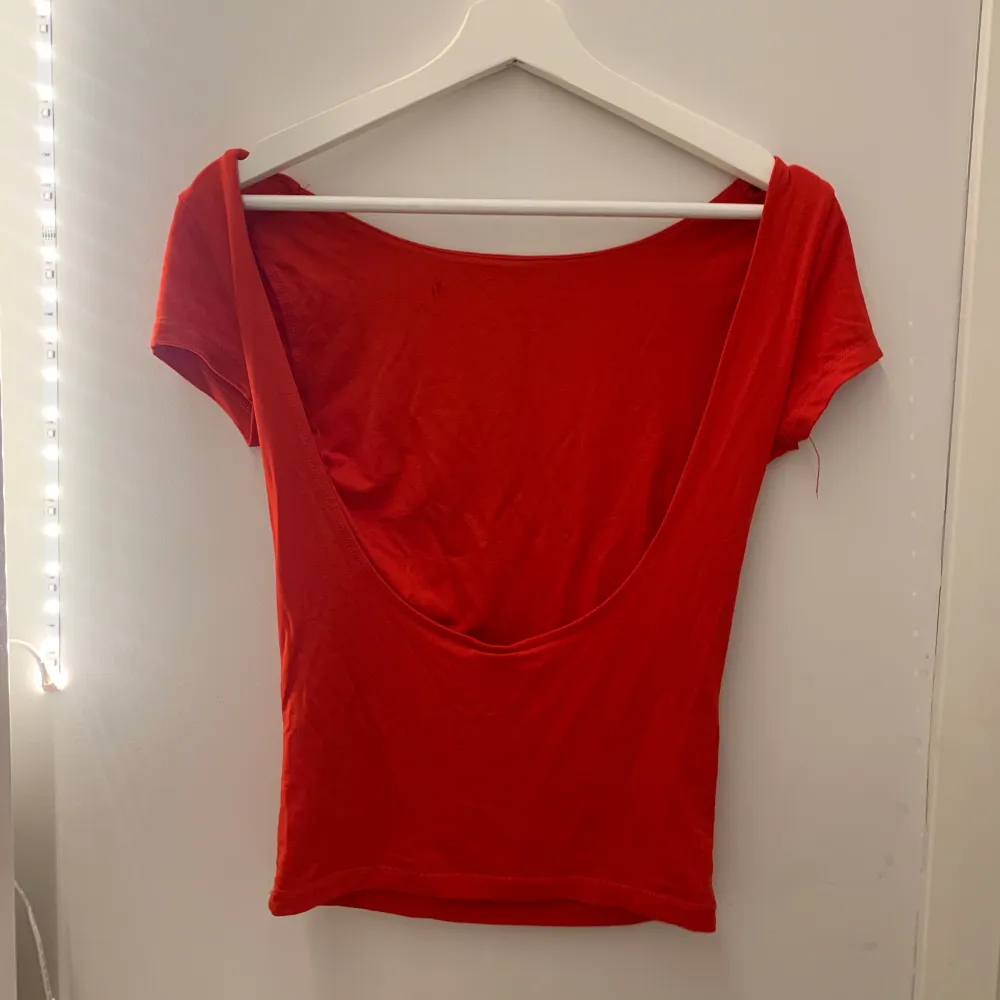 Snygg rygglös tröja från gina! Den är röd men ser orange ut på bilden, den är använd 1 gång och är i nyskick bara lite skrynklig💕. T-shirts.