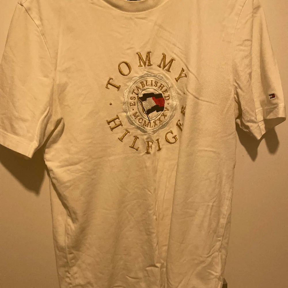 Tommy Hilfiger tshirt, köpt från självaste butiken, storlek M, i jätte bra skick, vit och guld, skriv för mer information.. T-shirts.