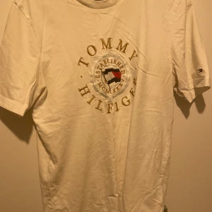 Tommy Hilfiger tshirt - Tommy Hilfiger tshirt, köpt från självaste butiken, storlek M, i jätte bra skick, vit och guld, skriv för mer information.