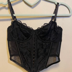 Svart korsett - Denna korsett är oanvänd då den är förliten, den passar någon med strl xs eller xxs, den har tre olika ställen att spänna och man kan ta av banden