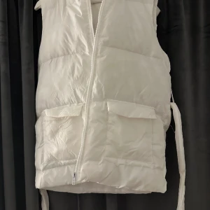 Vit väst  - Köpt 2 år sedan och är ganska använd men finns inga defekter. Varm och skön inför vår/ höst. Tillkommer även ”bälte” så man kan knyta runt midjan. 