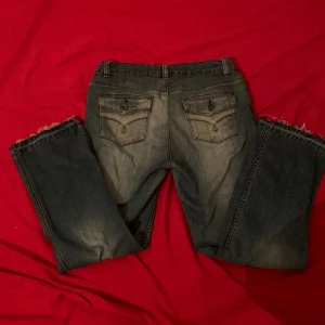 Coola jeans med detaljer på rumpan - Väldigt fina vintage jeans. Dom är ganska lågmidjade. Jag har sprätt ut byxorna där nere för att de skulle bli längre. Byxorna har tyvär blivit för små därför säljer jag dem. Skriv om du har frågor<3Midjan är 40 cm och innerbenslängden är 65 cm