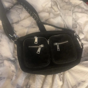 Väska (kom med pris) - Säljer en elegant och mångsidig mellanstor väska som passar perfekt för vardagliga tillfällen. Väskan är i utmärkt skick och har en stilfull design som gör den passande för olika situationer. Den har tillräckligt med utrymme för att rymma vanliga för