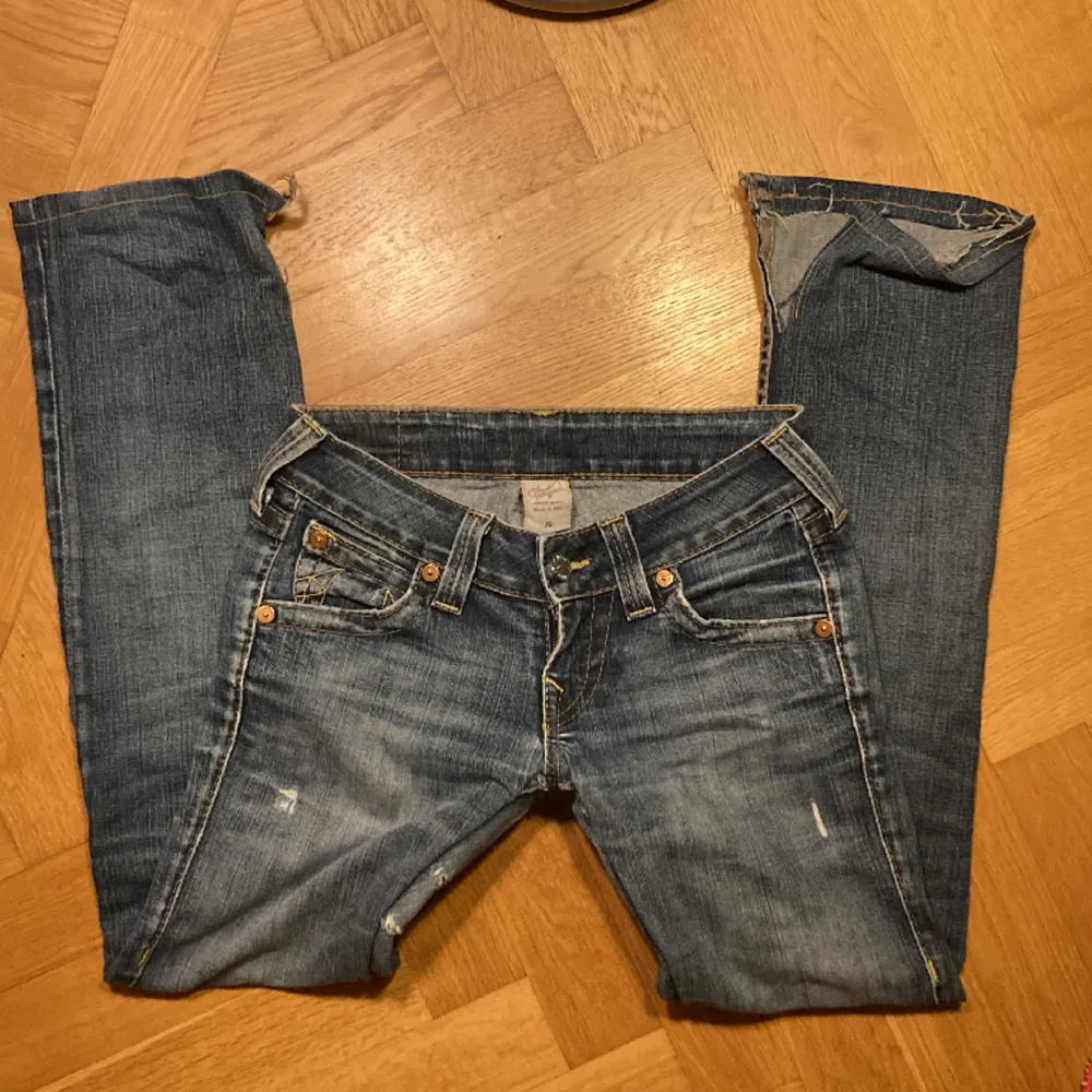 True religion jeans i ganska slitet skick, som dock gör dem ännu snyggare. De är slitna i skrevet som man ser på sista bilden, men sitter väldigt bra. Har klippt upp dem vid fötterna så att de sitter bootcut! De är lågmidjade och trendiga just nu!. Jeans & Byxor.
