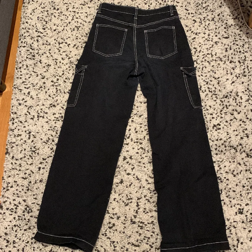 Högmidjade bekväma svarta cargo jeans med vita detaljer från H&M❣️. Jeans & Byxor.