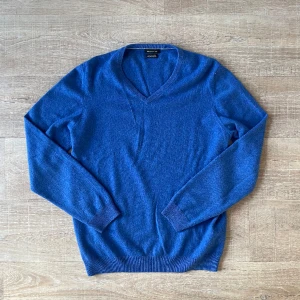 100% kashmir Massiomo Dutti Large - En super härligt tröja i 100% kashmir. V ringad i härlig blå färg. Storlek Large. Bra skick och några lagade hål på bröstet.