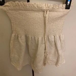 Vit/beige  kjol - Säljer en vit kjol från zara. Den har snäckor på snörena, tyvärr har några åkt av. Köptes o somras och användes mycket. Är i bra skick! Kom privat för mer bilder 🩷