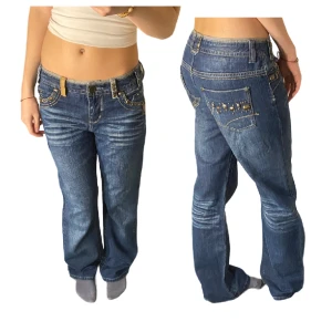 Lågmidjade Jeans - Jeans i hyfsat bra skick, några stenar som lossnat på rumpan. Utgå från mått men passar S. Inget slitage på själva byxan förutom två små fläckar (se i sista bilden).Lågmidjad passform. Mått; midjemått 37cm, innerbenslängd 75cm, ytterbenslängd 99cm. Fler bilder och frågor? Skicka dm.