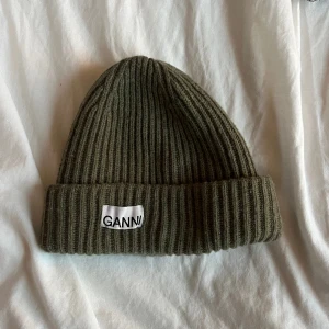 Ganni mössa - Säljer denna mörkgröna Ganni mössa i nyskick. 