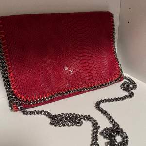 En röd skin väska med silver kedja band, använt en gång.