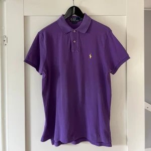 Polo Ralph Lauren Pikétröja - Lila pikétröja från Ralph Lauren. Väldigt bra skick och fräsch nu till våren och sommaren. Nypris 1200.  PRIS ÄR DISKUTERBART!