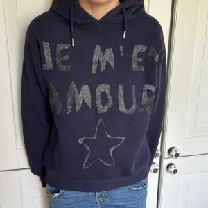 Je M’en amour Hoodie  - Säljs pga att den inte kommer till användning. Riktigt bra skick, stolek 134/140(jag är 1,58) Ligger bara i min garderob, därför vill jag bara av med den för att skapa mer plats❤️köpt för 250kr slut såld på Gina tricot hemsidan!