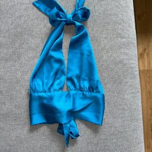 Blå fest topp - En fin fest topp som passar de flesta, går att knyta på lite olika sätt för att maximera användningen. Använd ett fåtal gånger på fest men är i fint skick.