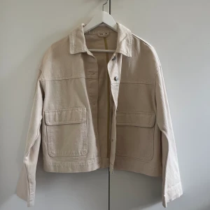 Beige jeansjacka - En kortare beige jeansjacka från Vero Moda som är perfekt för sommarn! Jackan är i storleken EUR 36.