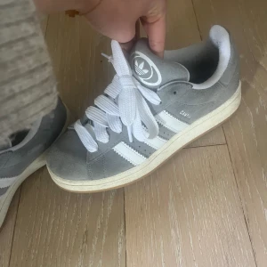 Adidas campus 00 gråa - Säljer mina adidas campus 00 i färgen grå då dom inte kommer till användning. Storlek 39 1/3. Dom har inga skador då dom har använts få gånger. Tvättas innan jag skickar dom till nya ägarna. Nypris 1300 kr💗