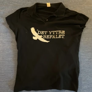 49. Svart det yttre befälet Polo XL - Det yttre befälet merch gjord av bandet själva. Polotröja i bra skick.