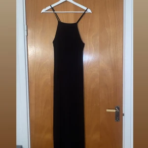 Lång svart klänning - Säljer en lång svart klänning i nyskick, endast använd en gång. Den är från gina tricot. Den har en korsning i ryggen och slit i sidan, väldigt fin detalj. Storlek xs💓