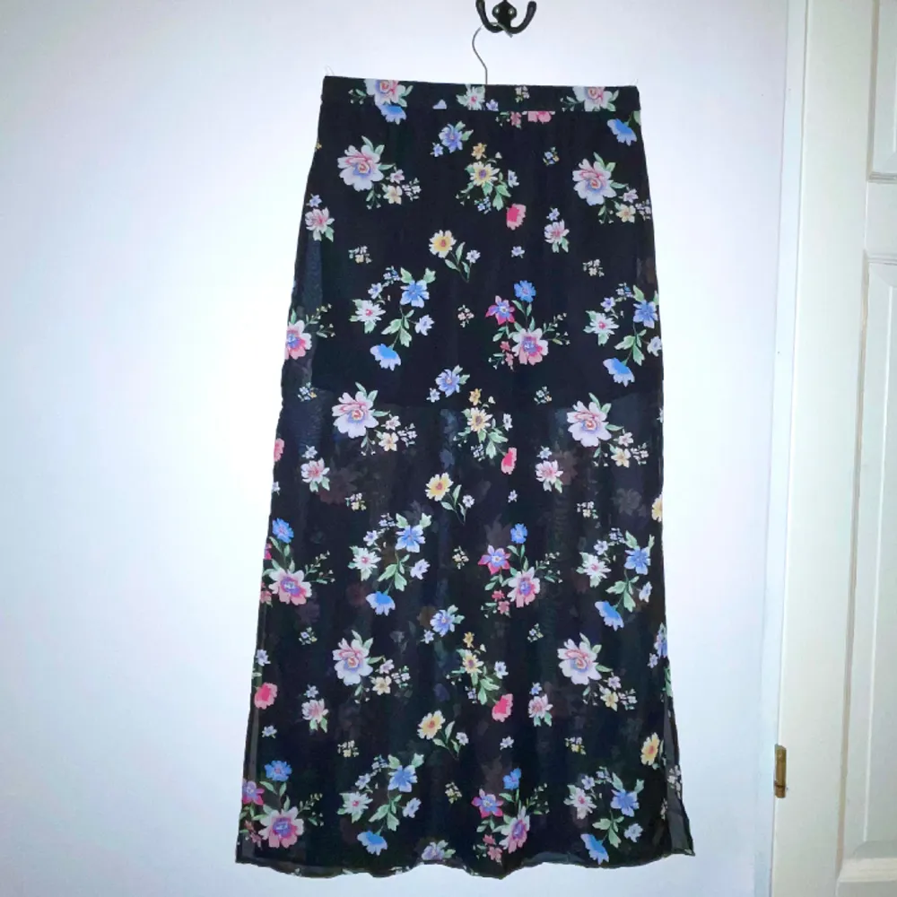 En lång svart kjol med blommor från H&M i storlek XS. Den har resårband i midjan och är väldigt stretchig, så skulle säga att den även passar för de som har storlek S och M 💞. Kjolar.