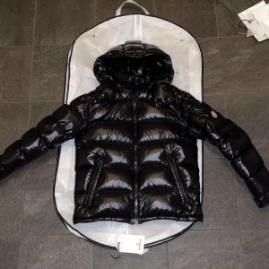 Svart Moncler Maya, size 2 - Maya utan några tecken på användning (9/10) size 2, självklart äkta. Samtliga tags kvar samt garderob.