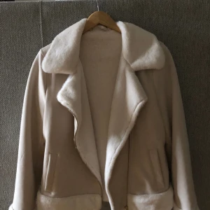 Jacka - En pälsfodrad, ljus jacka.Jättefresch och i nyskick. Otroligt mjuk och värmer super bra, fantastisk nu till våren med Linné elr t-shirt under men även nu på vintern med bra väder och en lite varmare tröja under. Använd en gång. 