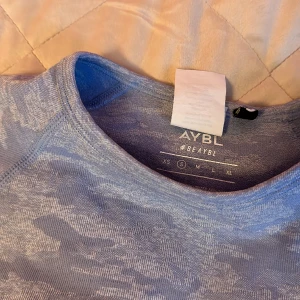 Croppad träningströja - Jättefin träningströja med camo-mönster från AYBL! Köpt här på Plick men aldrig använd av mig då den tyvärr är för liten :( står S men är mer som en XS. Inga synliga fel, färgen syns bäst på sista bilden 🫶🏼hör av er vid frågor! Frakt tillkommer