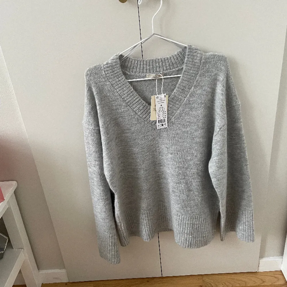 Säljer en v-ringad grå tröja från Gina tricot. Den är helt oanvänd med prislapp kvar. Köptes för 400 och säljer för 350:  Det är i Ginas premium qualiy, wool blend.   ❗️köparen står för frakten❗️. Stickat.